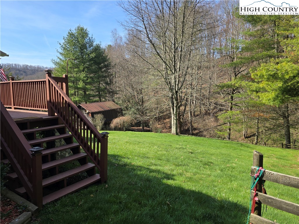 3160 Roundabout Road Creston, NC 28615 - Photo 11 of 50 a view of a backyard with wooden stairs and a bench