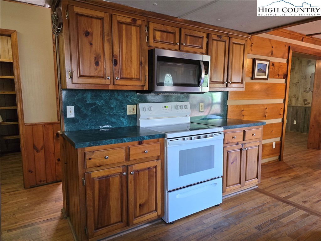 3160 Roundabout Road Creston, NC 28615 - Photo 19 of 50 a kitchen with stainless steel appliances granite countertop a stove microwave and cabinets