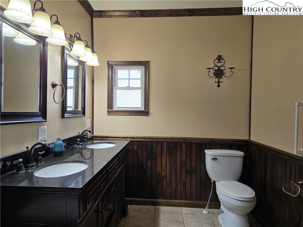 3160 Roundabout Road Creston, NC 28615 - Photo 26 of 50 a bathroom with a granite countertop toilet sink and mirror