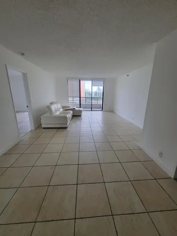a living room with a white checkered floor and a floor to ceiling window