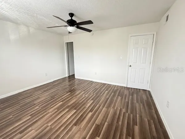 a view of empty room with wooden floor