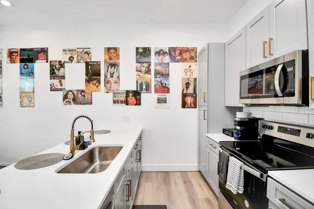 a kitchen with stainless steel appliances granite countertop a sink and stove top oven
