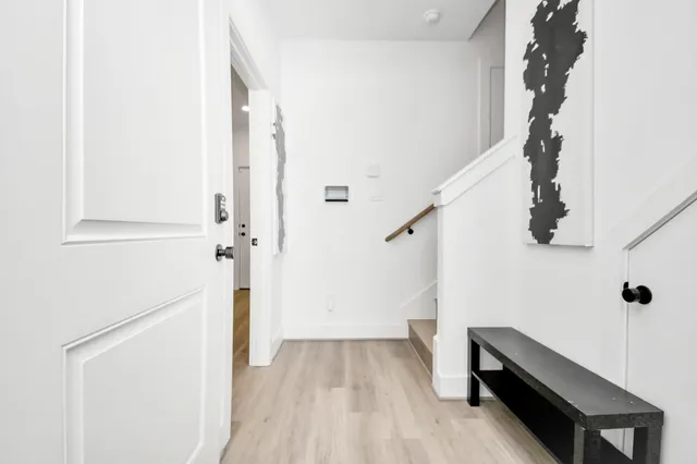 a view of hallway with stairs and wooden floor