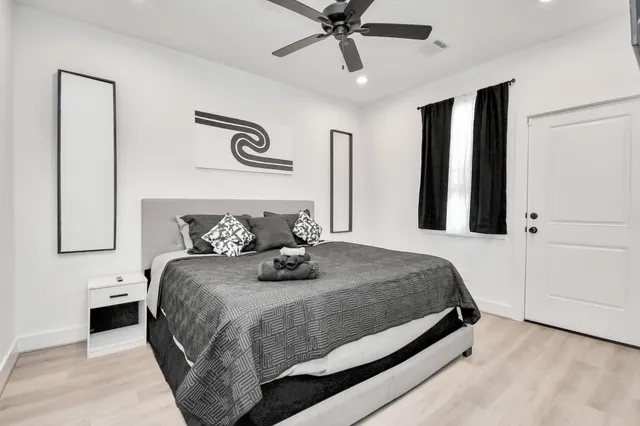 a bedroom with a large bed and a chandelier