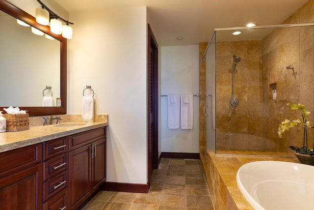 a bathroom with a granite countertop sink mirror bathtub and shower