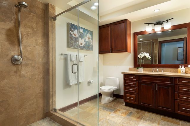 a spacious bathroom with a granite countertop sink toilet and shower