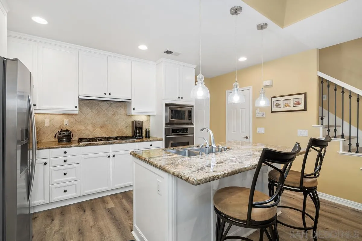 2124 Historic Decatur Road San Diego, CA 92106 - Photo 11 of 40 a kitchen with stainless steel appliances granite countertop a stove a sink dishwasher and a refrigerator with wooden floor