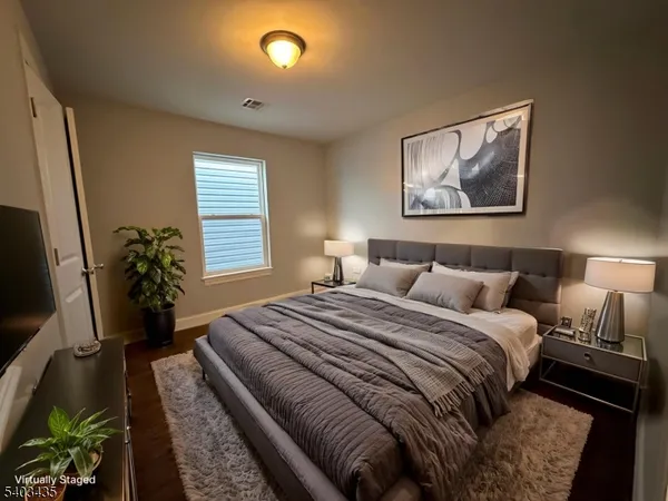 a bedroom with bed and a potted plant