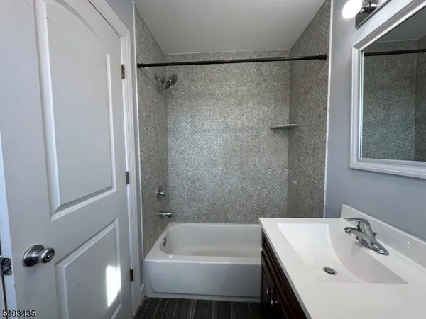 a bathroom with a tub a sink and a shower