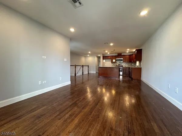 a view of a big room with wooden floor a kitchen