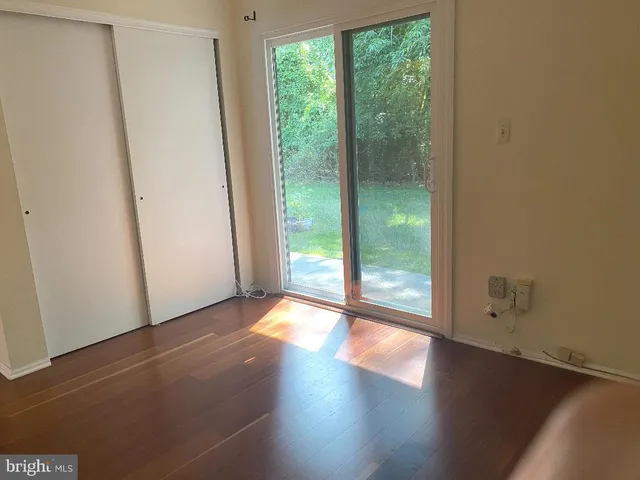 a view of a big room with wooden floor and windows
