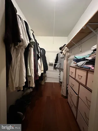 a view of walk in closet with clothes and shoes