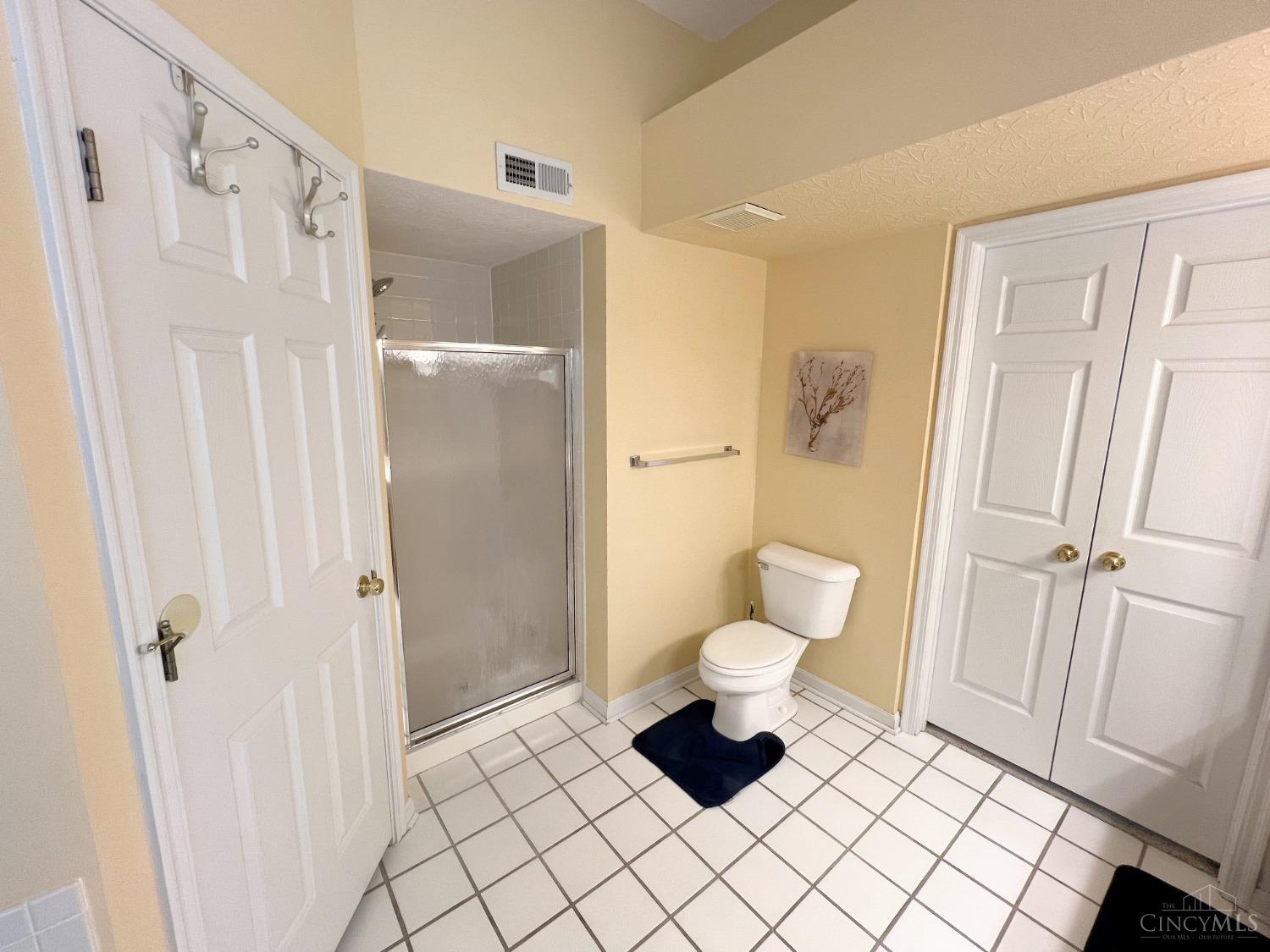 8408 Ridge Pointe Court, Unit 13 Reading, OH 45237 - Photo 19 of 39 Here's another angle of the primary bathroom with the walk-in closet, separate shower and toilet with ceramic tile flooring.
