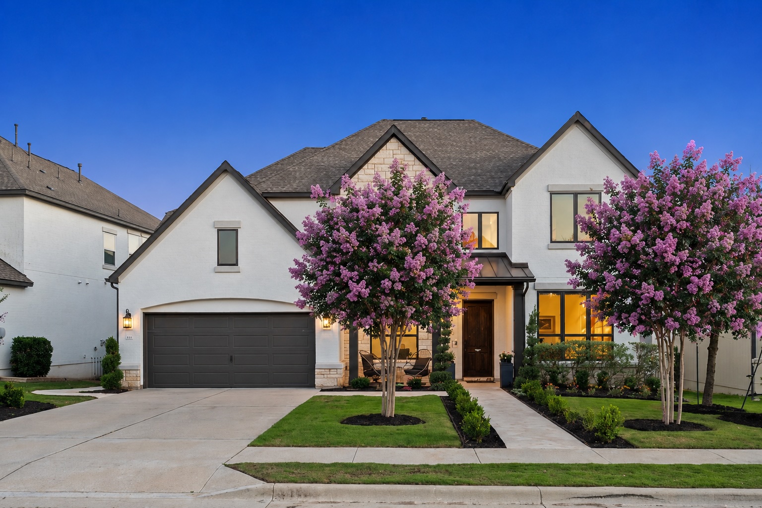 1221 Siena Sunset Road Leander, TX 78641 - Photo 2 of 39 A well-manicured front yard with blooming trees frames this contemporary white stucco home.