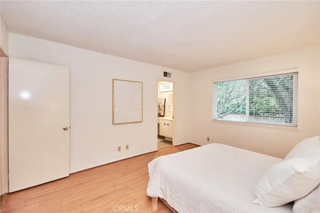 a bedroom with a large bed and a chandelier