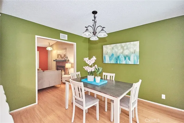 a view of a dining room with furniture a chandelier and wooden floor