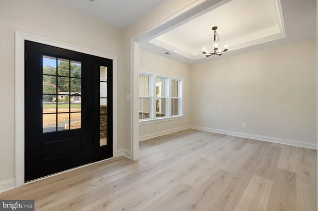 a view of empty room with wooden floor and window