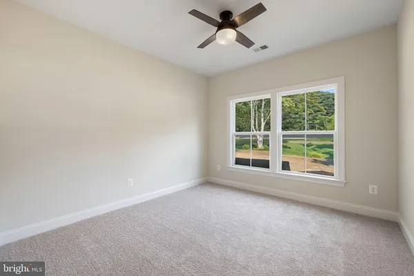 a view of an empty room with wooden floor fireplace and a window
