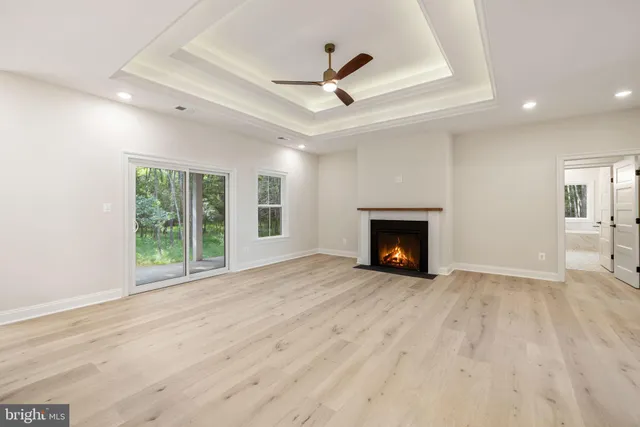 a large kitchen with stainless steel appliances granite countertop a refrigerator a sink dishwasher a stove and a dining table with wooden floor