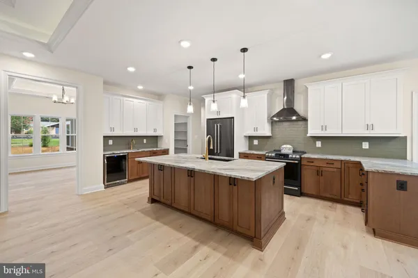 a kitchen with stainless steel appliances granite countertop a sink a stove and a wooden floors
