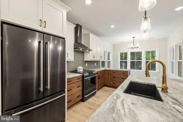 a kitchen with stainless steel appliances granite countertop a stove a refrigerator a sink and a oven