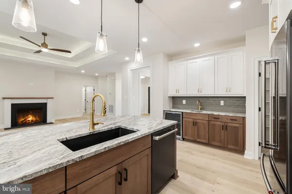 a large kitchen with kitchen island a large counter top space appliances and cabinets
