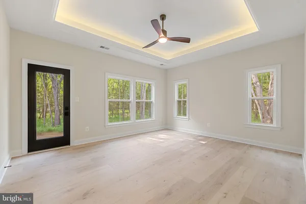an empty room with a ceiling fan and carpet