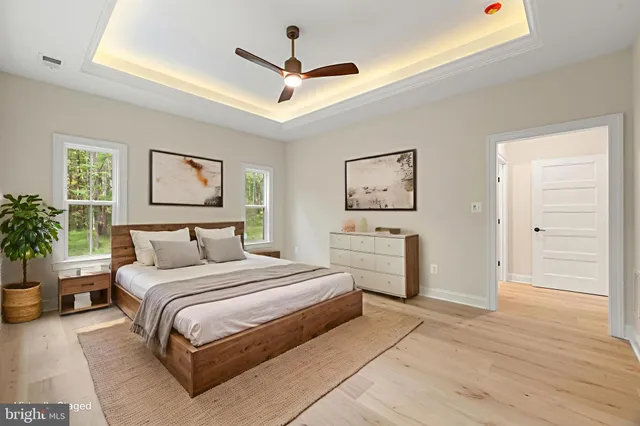 an empty room with wooden floor fireplace and windows