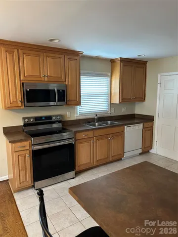 a kitchen with stainless steel appliances a stove a sink and a microwave