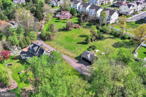 an aerial view of a house with a garden and lake view