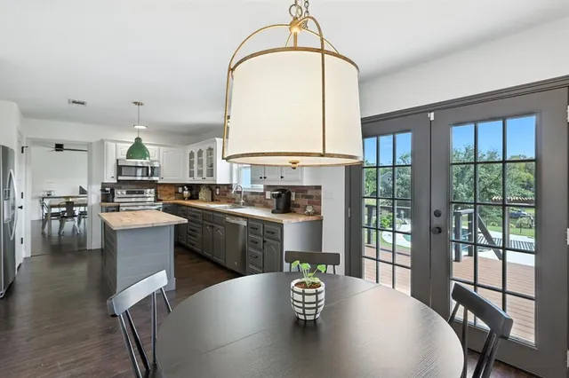 a kitchen with a table chairs stove and wooden floor