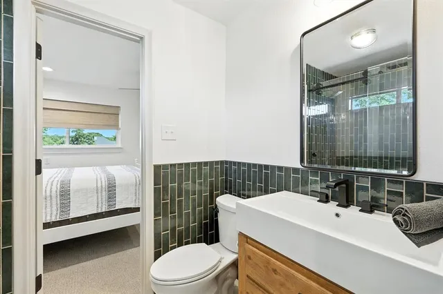 a bathroom with a sink a toilet and shower