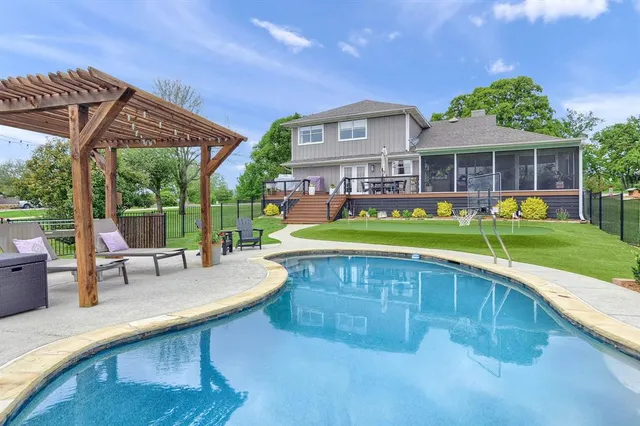 a swimming pool with outdoor seating and yard