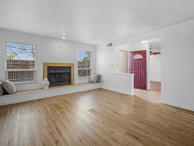 wooden floor fireplace and windows in an empty room