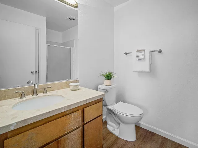 a bathroom with a granite countertop sink a toilet and a mirror