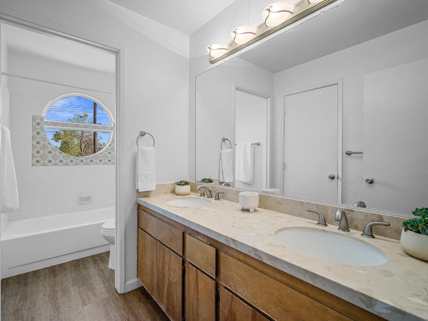 1519 Hood Road, Unit F Sacramento, CA 95825 - Photo 16 of 28 a bathroom with a tub a sink and wooden floor
