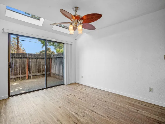 a view of a livingroom with wooden floor and a ceiling fan