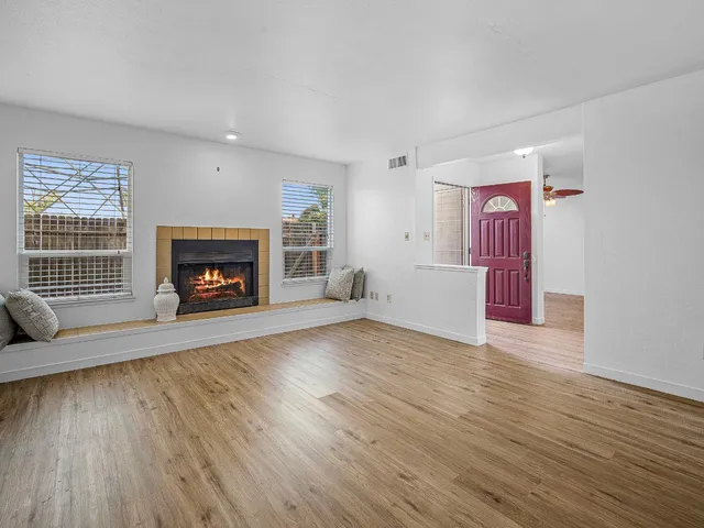 a view of empty room with wooden floor and fireplace
