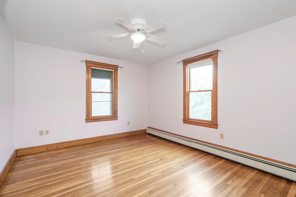 13-15 Fordham Road Newton, MA 02465 - Photo 19 of 30 an empty room with wooden floor chandelier fan and windows