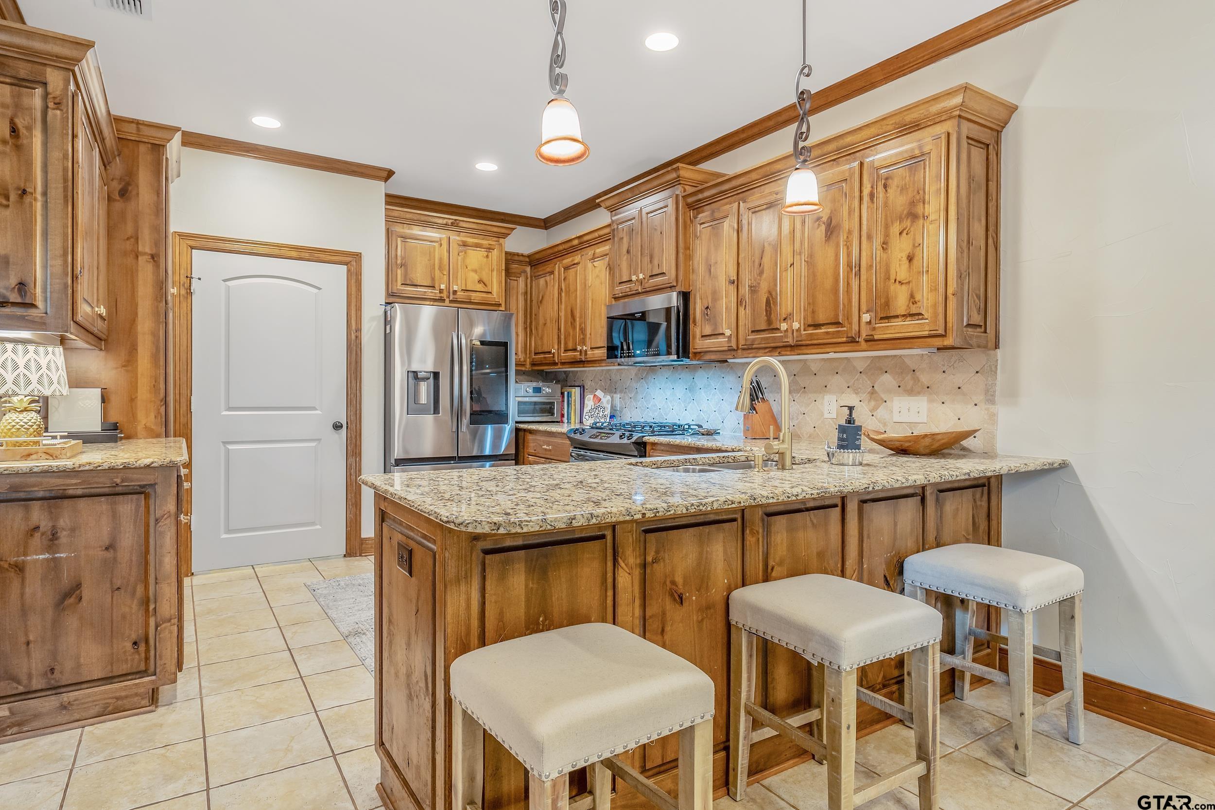 7216 Princedale Tyler, TX 75703 - Photo 9 of 27 a kitchen with granite countertop a sink and a refrigerator
