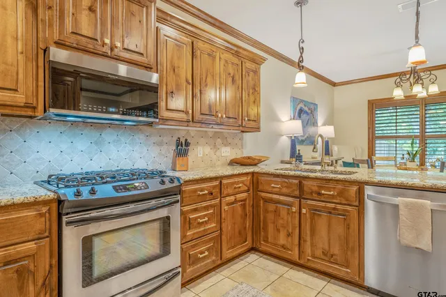 a kitchen with stainless steel appliances granite countertop a stove a sink and a microwave