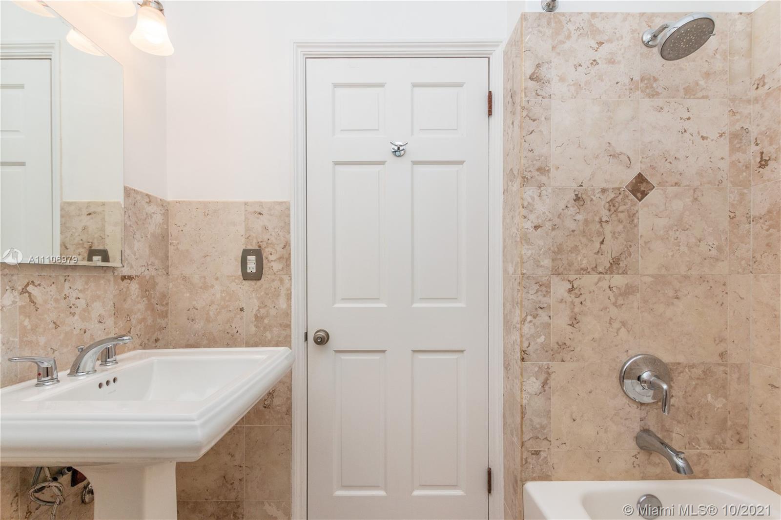 5173 Alton Road Miami Beach, FL 33140 - Photo 14 of 31 a bathroom with a sink a mirror and shower