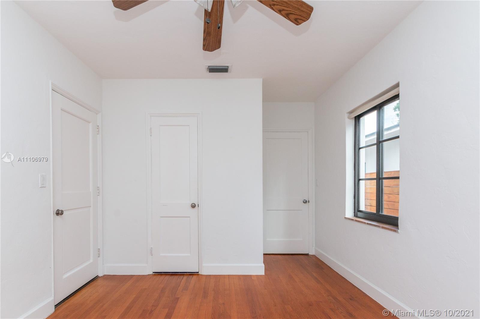 5173 Alton Road Miami Beach, FL 33140 - Photo 17 of 31 an empty room with wooden floor cabinet and windows