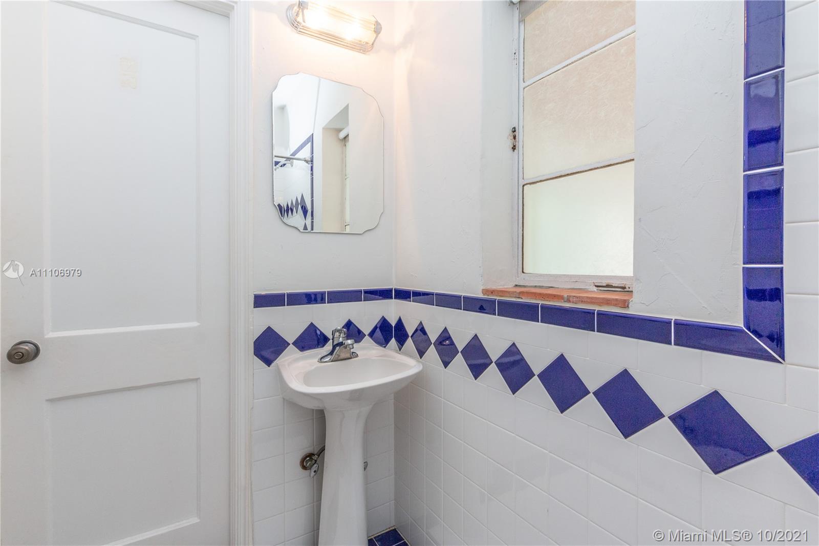 5173 Alton Road Miami Beach, FL 33140 - Photo 18 of 31 a bathroom with a sink and a mirror