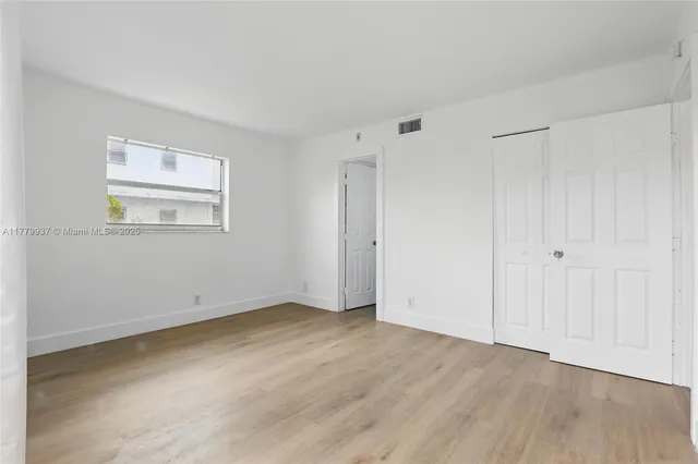 a view of a room with wooden floor and bathroom