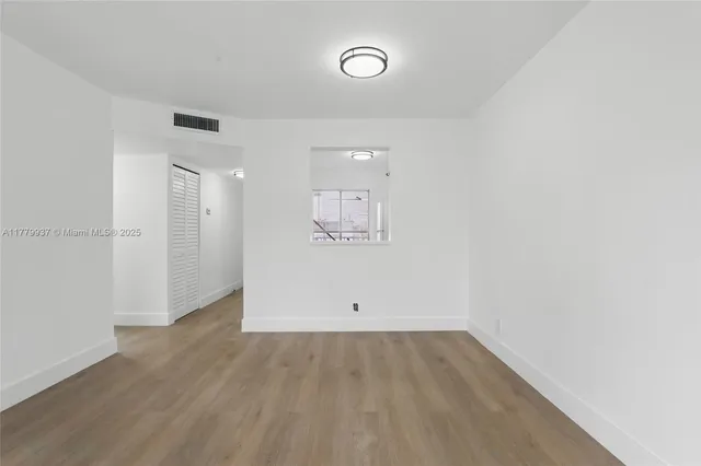 a view of a room with wooden floor and window