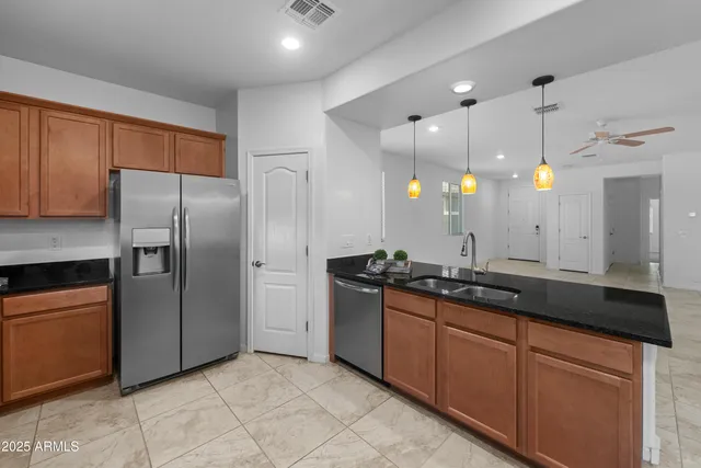 a kitchen with stainless steel appliances granite countertop a sink a counter space and cabinets