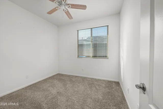 a view of a room with a ceiling fan and a window
