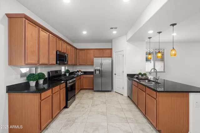 a kitchen with stainless steel appliances granite countertop a stove a sink dishwasher a refrigerator and a oven