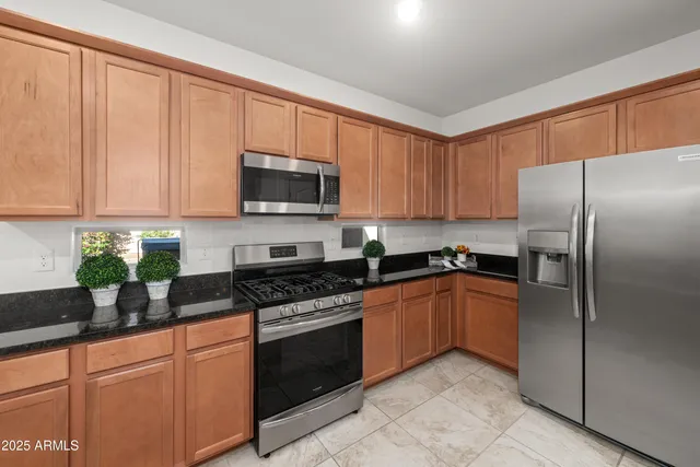 a kitchen with stainless steel appliances granite countertop a refrigerator sink and cabinets